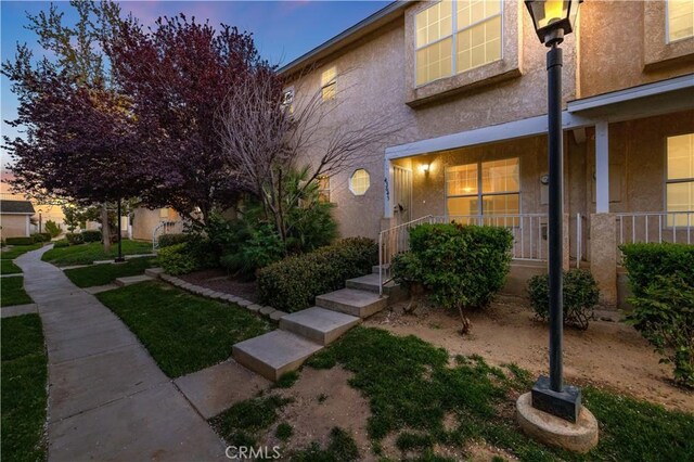 townhome / multi-family property featuring stucco siding and a porch