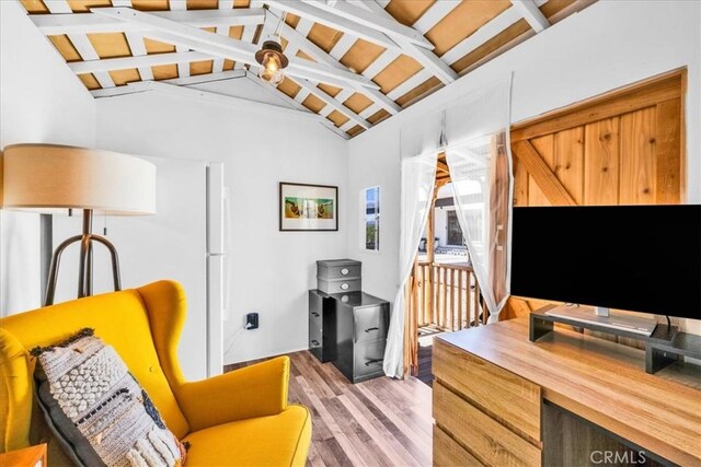 interior space featuring lofted ceiling with beams and light wood finished floors