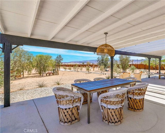 2837 Border Ave, Joshua Tree, CA 92252 - view of patio with outdoor dining space, a mountain view, and a fenced backyard