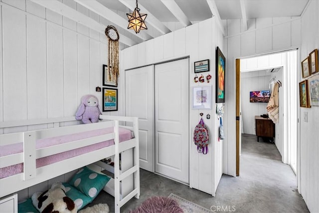 2837 Border Ave, Joshua Tree, CA 92252 - bedroom featuring beamed ceiling, concrete flooring, a closet, and wood walls