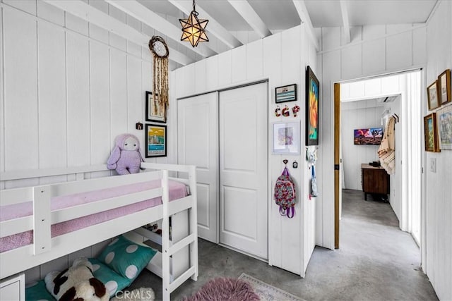 2837 Border Ave, Joshua Tree, CA 92252 - bedroom featuring beamed ceiling, concrete floors, a closet, and wood walls
