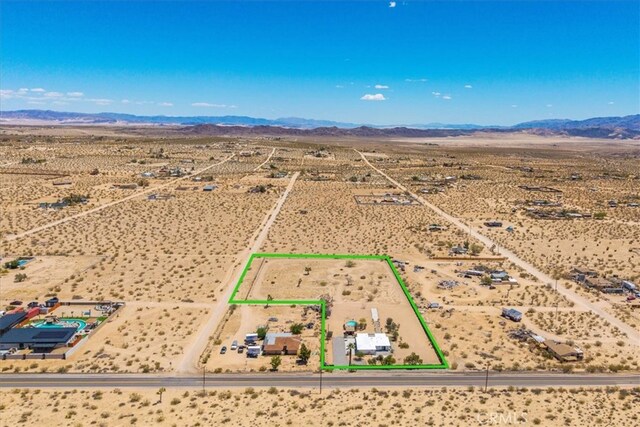 drone / aerial view with a desert view, a mountain view, and a rural view