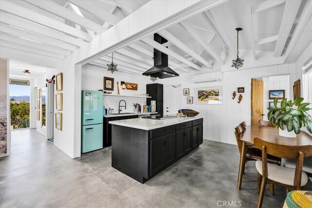 kitchen featuring a sink, freestanding refrigerator, concrete floors, dark cabinetry, and wall chimney exhaust hood