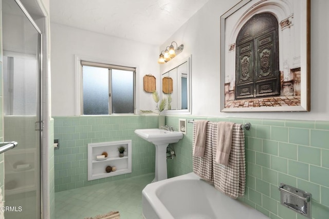 bathroom featuring tile walls, a shower stall, and a wainscoted wall
