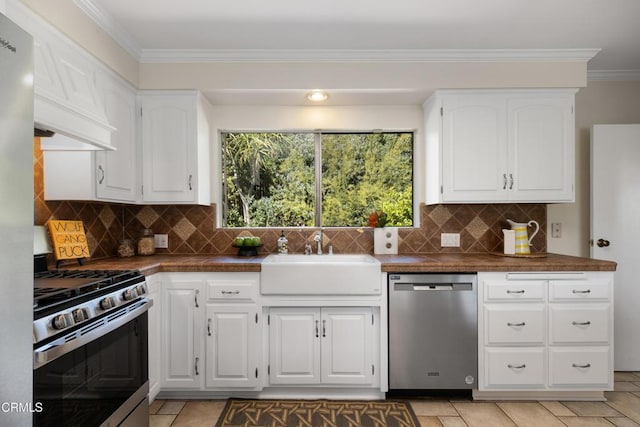 kitchen featuring a sink, appliances with stainless steel finishes, a healthy amount of sunlight, and dark countertops