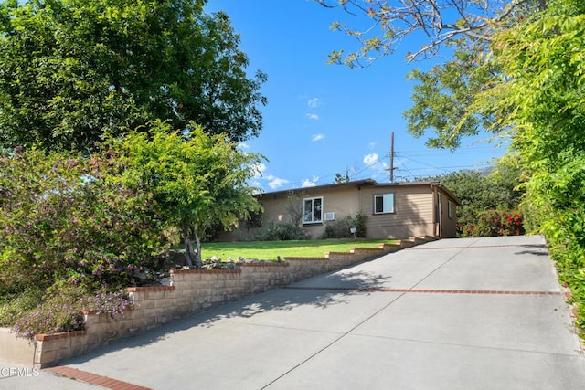 ranch-style home featuring a patio, stucco siding, and a front yard