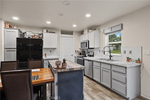 5736 La Porte Rd, Bangor, CA 95914 - kitchen with butcher block countertops, light wood-type flooring, tasteful backsplash, a sink, and appliances with stainless steel finishes