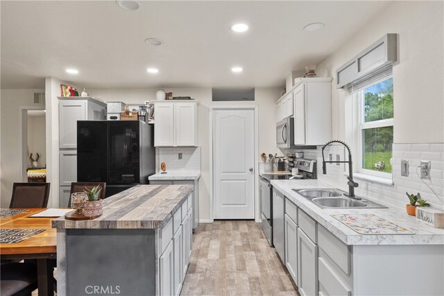 5736 La Porte Rd, Bangor, CA 95914 - kitchen featuring appliances with stainless steel finishes, a sink, light wood finished floors, wood counters, and decorative backsplash
