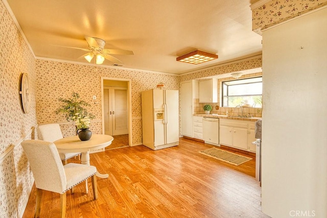 dining area with ornamental molding, ceiling fan, light wood finished floors, and wallpapered walls