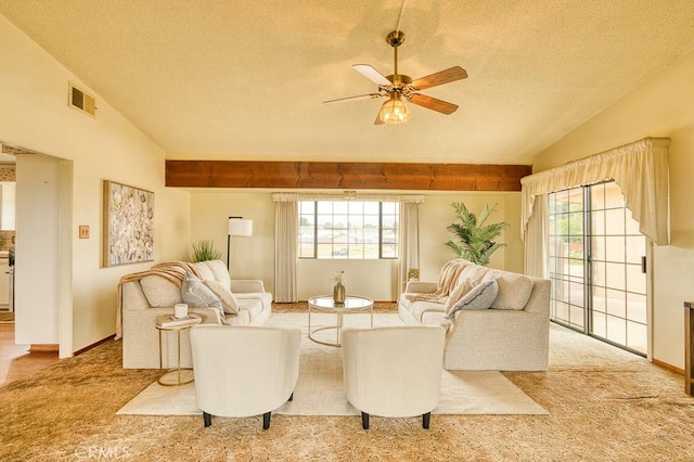 living room featuring a healthy amount of sunlight, a ceiling fan, a textured ceiling, and visible vents