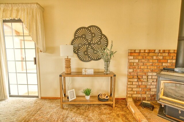 interior details featuring carpet floors, a wood stove, baseboards, and visible vents