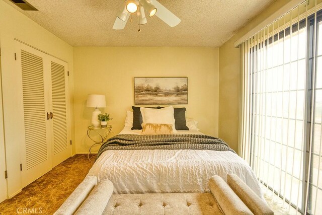 carpeted bedroom with visible vents, a ceiling fan, a textured ceiling, and a closet