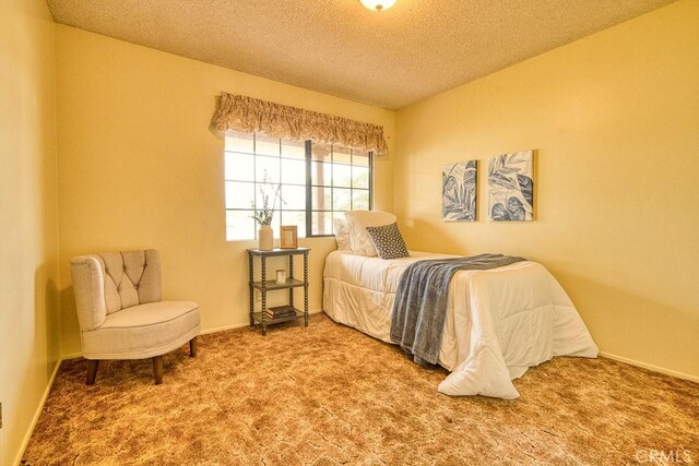 carpeted bedroom with a textured ceiling and baseboards