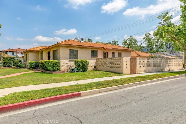 1422 W Riverside Dr, Burbank, CA 91506 - view of front facade featuring fence private yard, a tile roof, a front yard, and stucco siding
