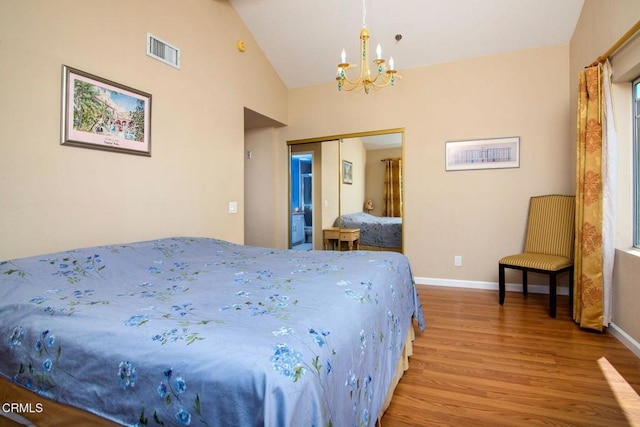 bedroom featuring visible vents, a closet, an inviting chandelier, lofted ceiling, and wood finished floors
