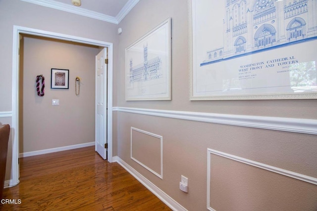 hall with baseboards, ornamental molding, and wood finished floors