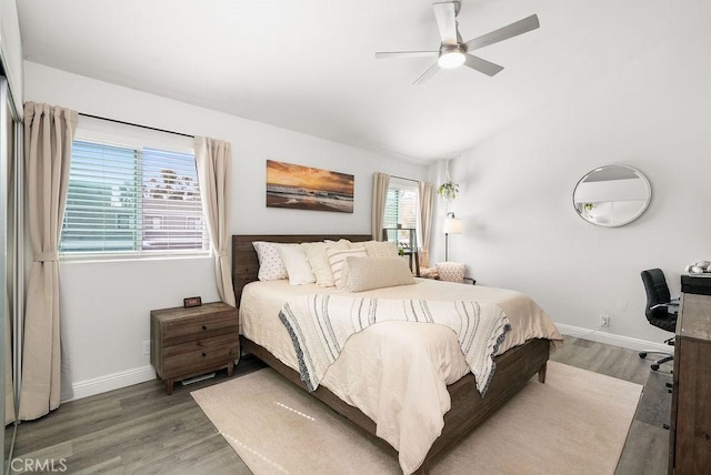 bedroom featuring baseboards, a ceiling fan, light wood-style floors, and vaulted ceiling