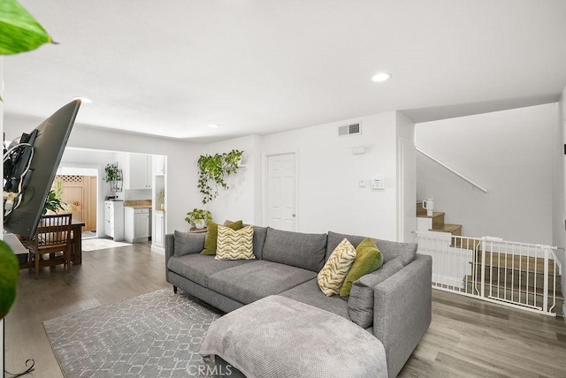 living room featuring stairway, recessed lighting, wood finished floors, and visible vents