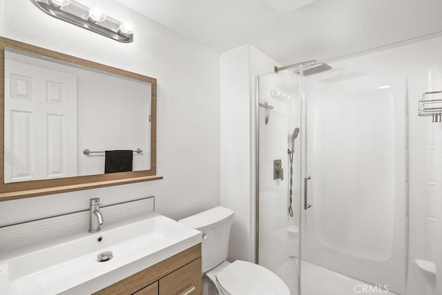 bathroom featuring vanity, a stall shower, and toilet