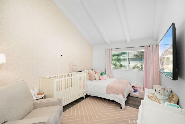 bedroom with vaulted ceiling with beams and wood finished floors