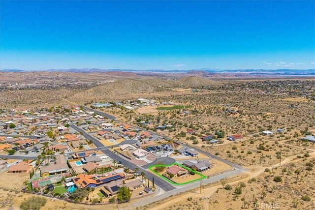 drone / aerial view featuring a desert view, a mountain view, and a residential view