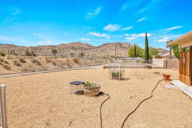 view of yard featuring a fenced backyard and a mountain view