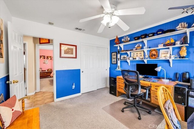 carpeted office space featuring a ceiling fan and visible vents
