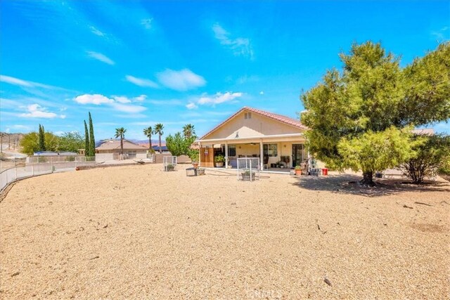 rear view of house featuring fence and a patio area