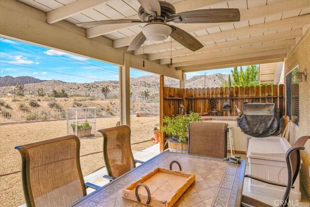 view of patio / terrace featuring a fenced backyard, a ceiling fan, and a mountain view