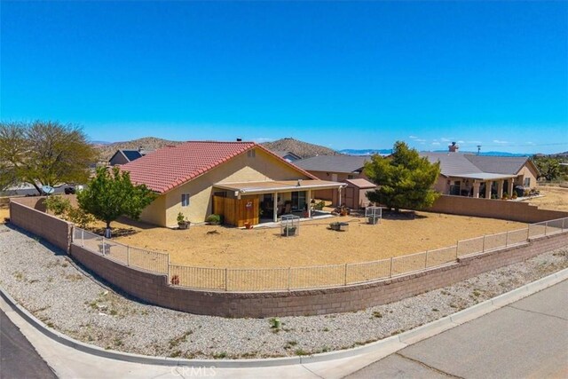 ranch-style home with fence private yard, stucco siding, and a tile roof