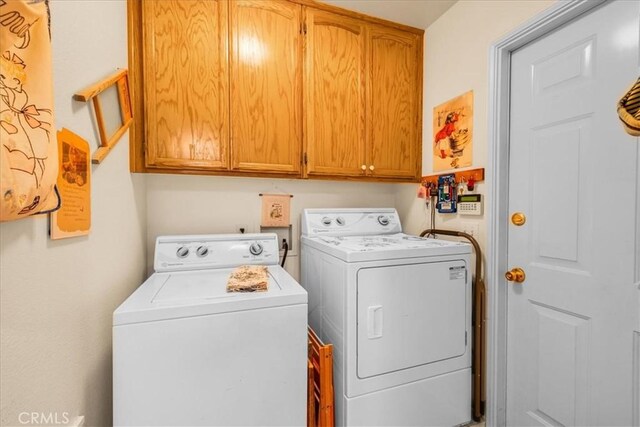 clothes washing area featuring cabinet space and washer and dryer