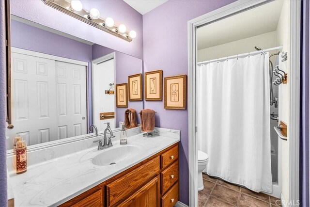 bathroom with toilet, tile patterned floors, a shower with curtain, and vanity