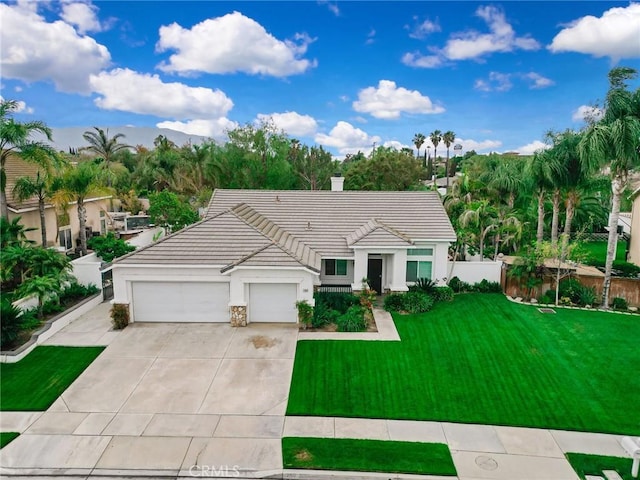 ranch-style house with a tile roof, a garage, stucco siding, a front yard, and driveway