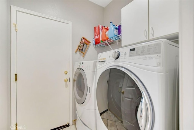 laundry room with cabinet space, washing machine and dryer, and light tile patterned flooring