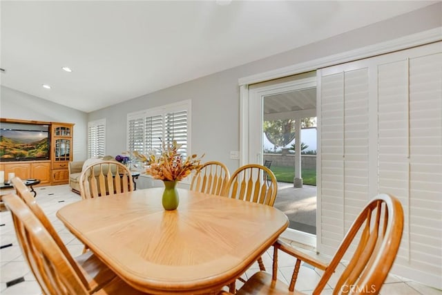dining area featuring recessed lighting, baseboards, light tile patterned floors, and lofted ceiling