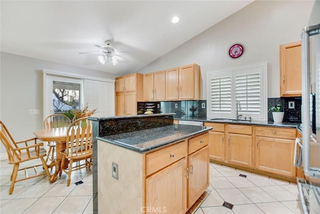 kitchen featuring a sink, backsplash, lofted ceiling, and light brown cabinets