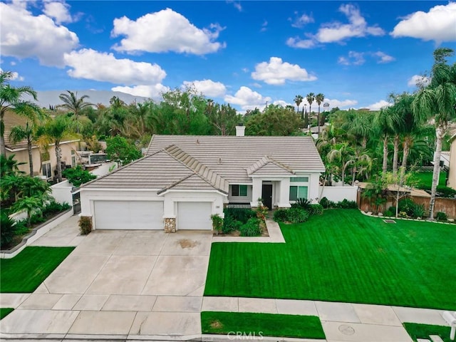 ranch-style house featuring a tile roof, a garage, a front lawn, concrete driveway, and stucco siding