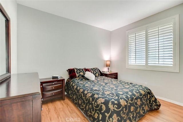 bedroom with baseboards and wood finished floors