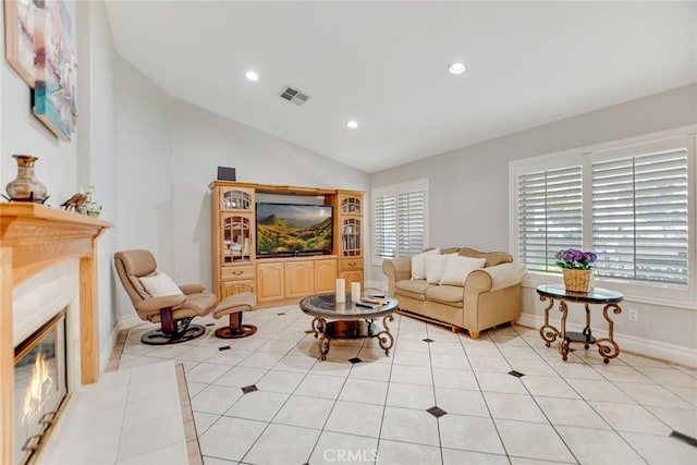 living room featuring visible vents, a glass covered fireplace, recessed lighting, light tile patterned floors, and vaulted ceiling