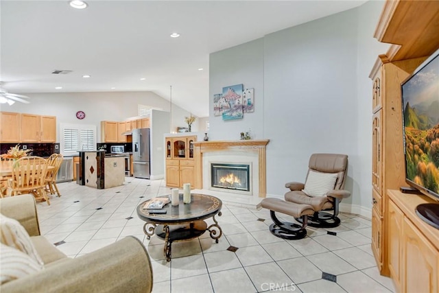 living area with visible vents, lofted ceiling, a glass covered fireplace, recessed lighting, and light tile patterned flooring