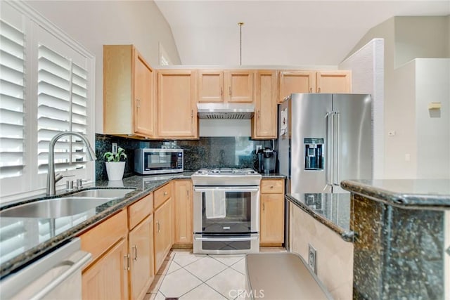 kitchen with light tile patterned floors, light brown cabinetry, vaulted ceiling, and stainless steel appliances