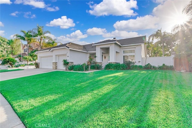 view of front of house with driveway, a front yard, a garage, fence, and stucco siding