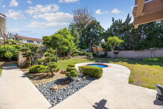 view of yard featuring a fenced backyard and an in ground hot tub