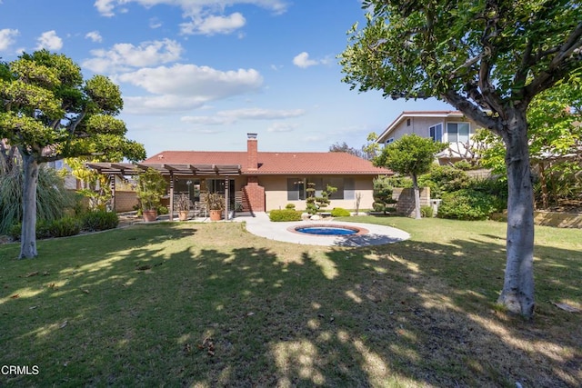 rear view of house with a hot tub, a pergola, a yard, and a patio