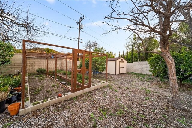 2450 Cameron Ave, Covina, CA 91724 - view of yard featuring an outdoor structure, a shed, a fenced backyard, and a vegetable garden