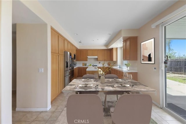 19131 Camassia Ct, Riverside, CA 92508 - kitchen featuring light countertops, stainless steel refrigerator with ice dispenser, light tile patterned floors, under cabinet range hood, and baseboards