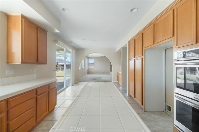 19131 Camassia Ct, Riverside, CA 92508 - kitchen featuring stainless steel double oven, arched walkways, light tile patterned floors, tile countertops, and recessed lighting