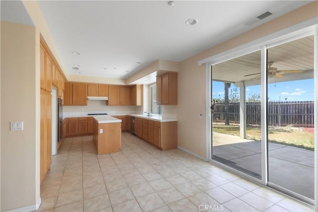 19131 Camassia Ct, Riverside, CA 92508 - kitchen featuring light countertops, a sink, a center island, cooktop, and under cabinet range hood