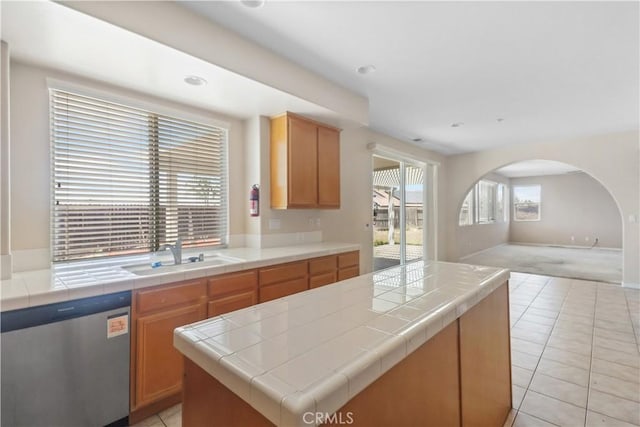 19131 Camassia Ct, Riverside, CA 92508 - kitchen with stainless steel dishwasher, a sink, open floor plan, arched walkways, and light tile patterned flooring