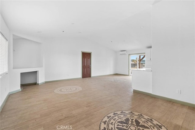 12185 Atsina Rd, Phelan, CA 92371 - unfurnished living room with light wood-style floors, baseboards, vaulted ceiling, and an AC wall unit